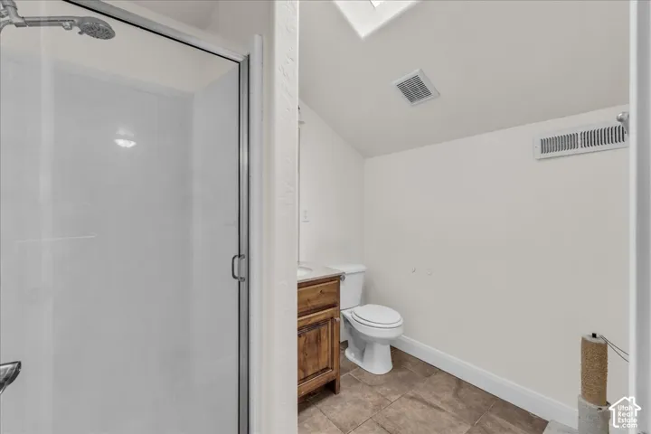 Walk-in shower with clear glass enclosure and overhead rain shower