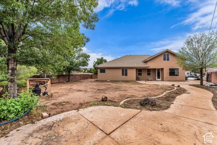 Expansive outdoor area with a stucco exterior, multiple windows, and a paved patio