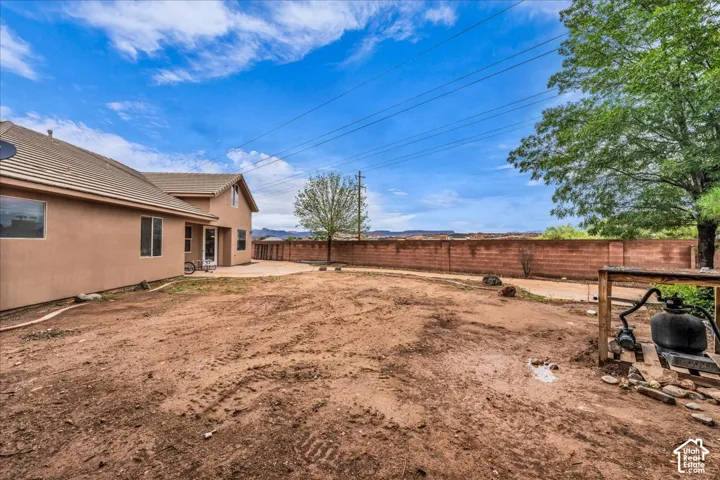 Spacious rear yard with a perimeter masonry wall and a concrete patio