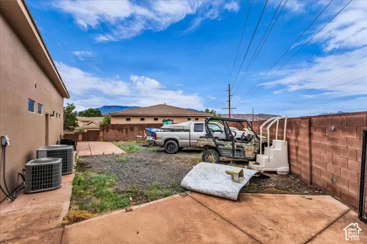 Stucco exterior with multiple HVAC units and a concrete patio