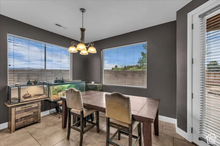 Recessed lighting, corner windows, tile flooring, and a glass-paneled door