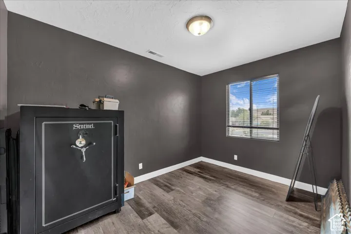 Room featuring wood-finish flooring, a single window, and a flush-mount ceiling light