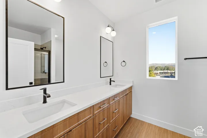 Dual sink vanity with wood-finish cabinetry and white countertops
