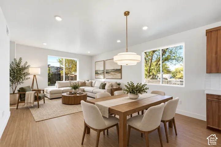 Open-concept living area with LVP flooring, recessed lighting, and large windows