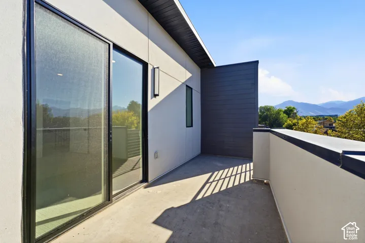 Private exterior balcony with modern wall sconce, and mountain scenery
