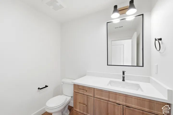 Wood-finish vanity with white rectangular sink and matte black faucet