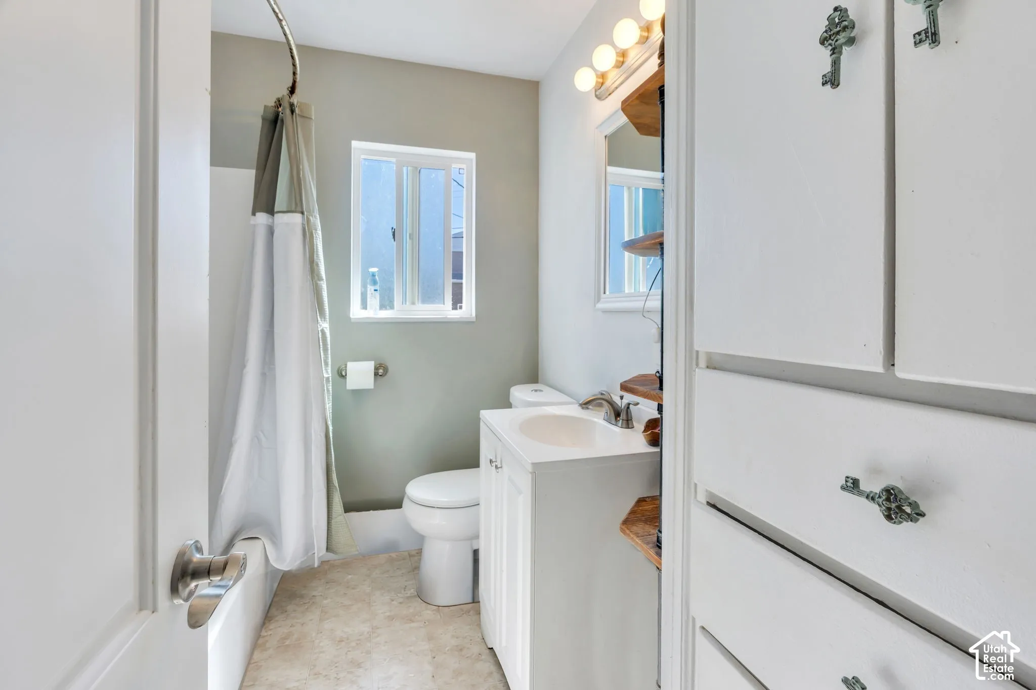 White bathroom vanity with single sink and chrome faucet
