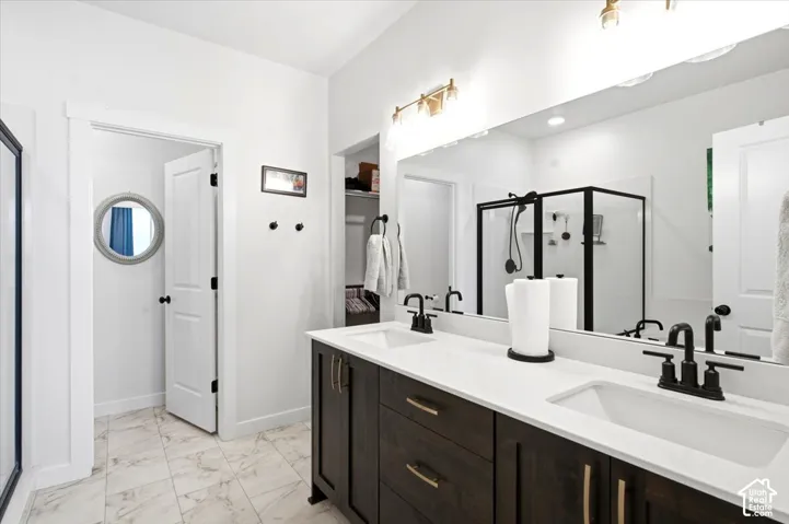 Primary suite with walk-in closet, double vanity, separate tub and shower, and tucked-away linen storage