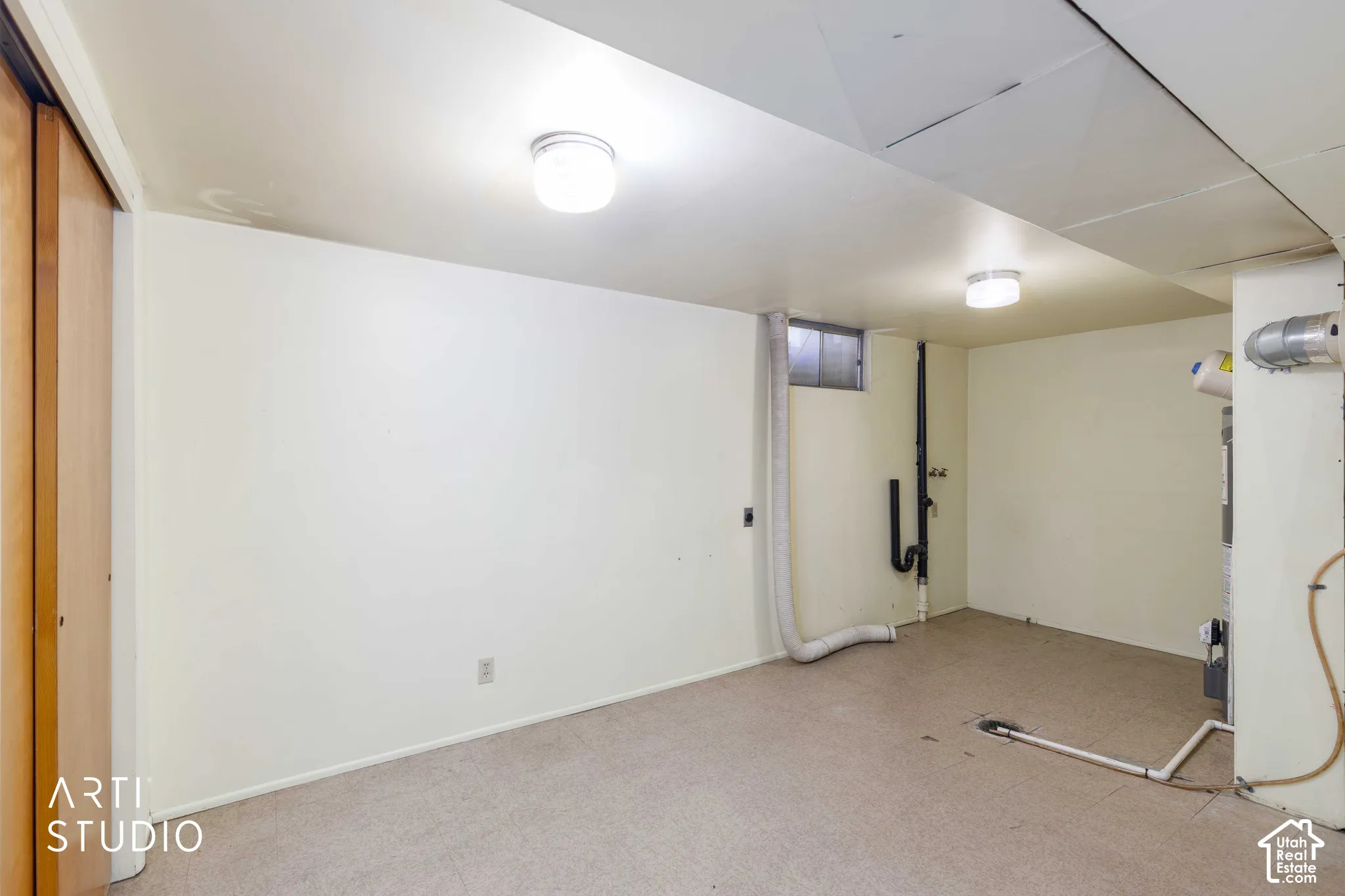 Carpeted floor, neutral wall paint, two ceiling-mounted light fixtures, small window, and built-in closet with wood-finish doors