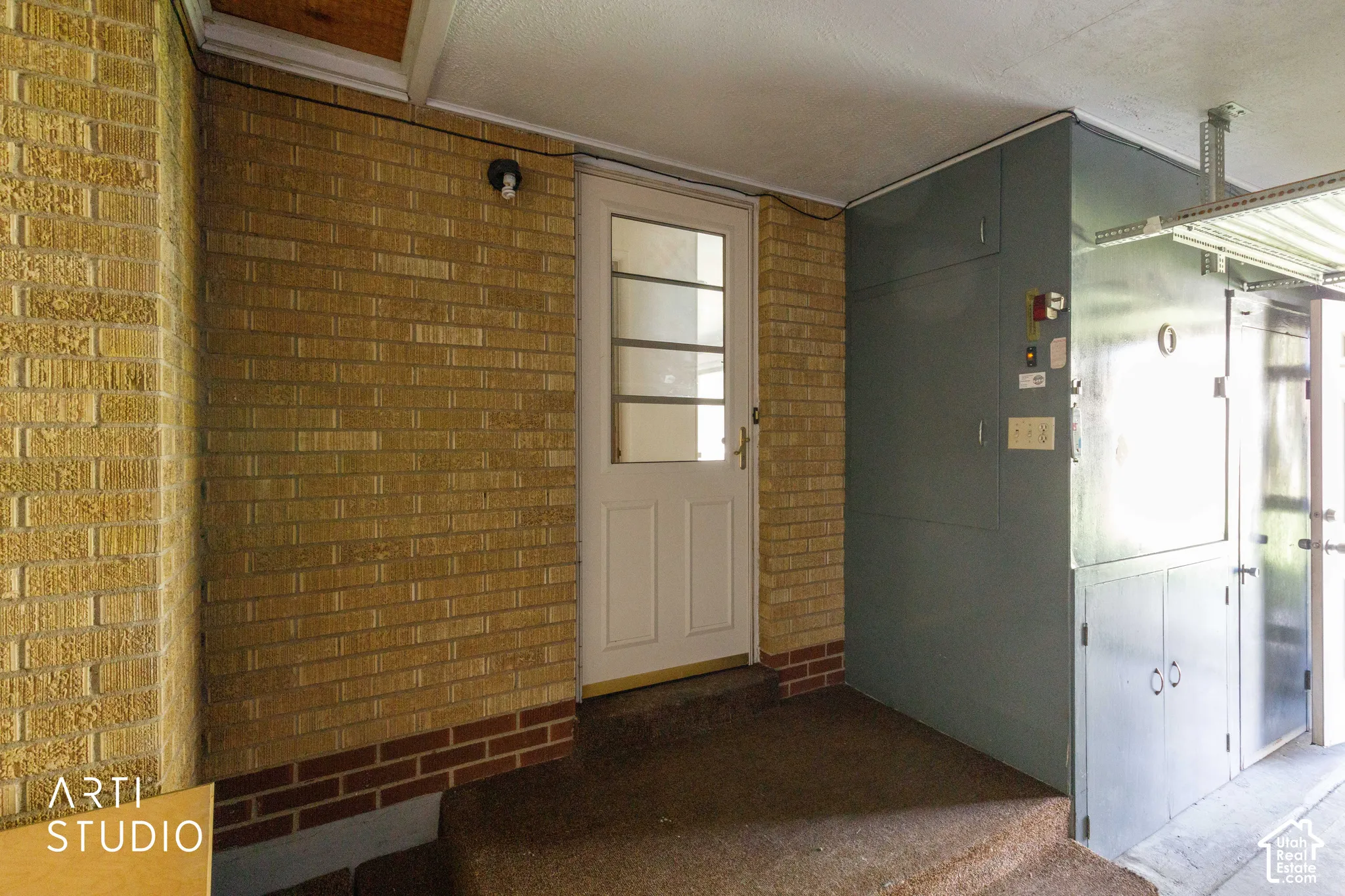 Brick exterior wall with a white paneled door