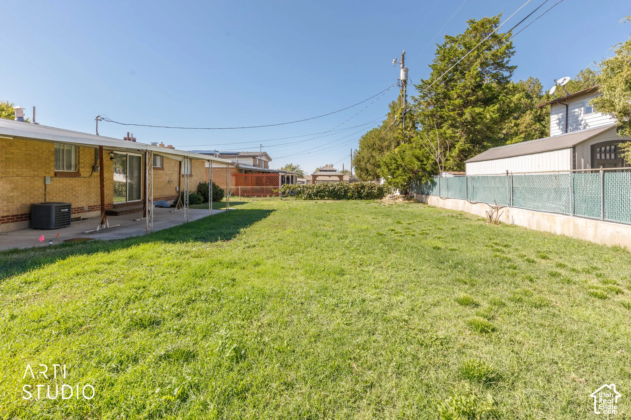 Expansive grassy yard with a covered patio and sliding glass door access
