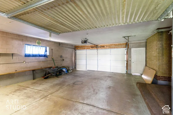 Concrete block walls with a single garage door, an additional access door, and a single window