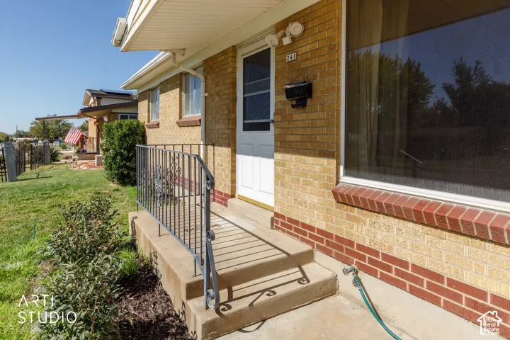Brick exterior with a concrete porch and wrought iron railing