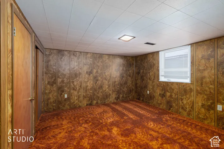 Room featuring wood-finish wall panels and a white grid ceiling