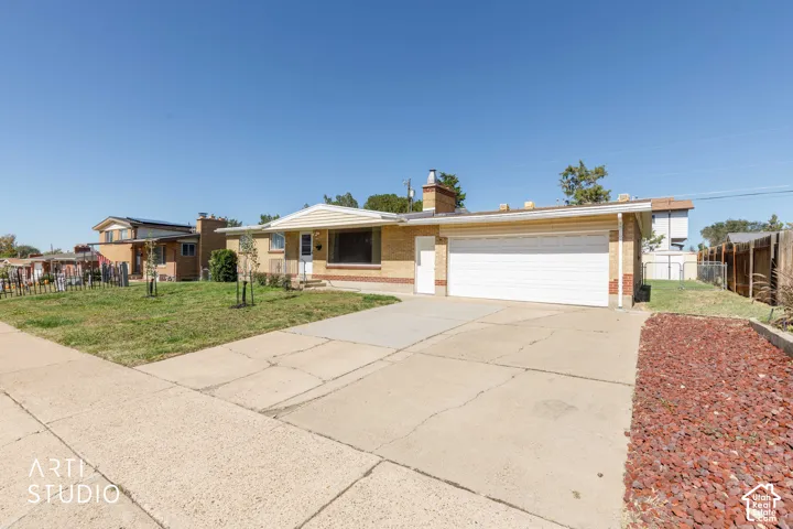 Brick facade home featuring an attached two-car garage, concrete driveway, and front lawn