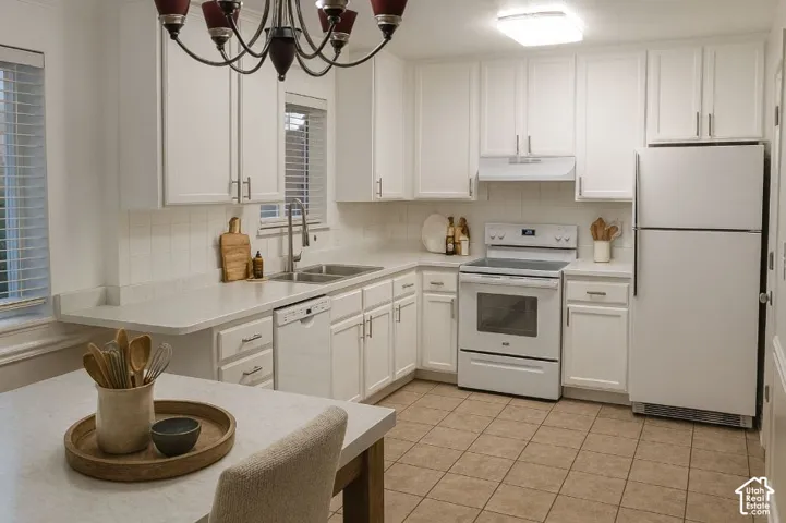 White cabinetry, tile flooring, and integrated white appliances