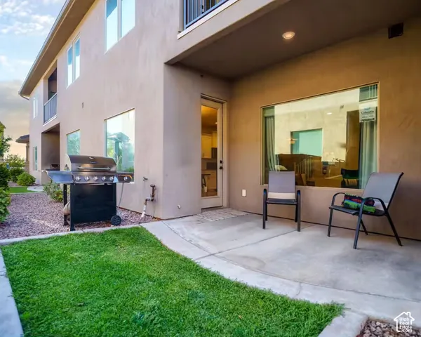 Private concrete patio with a grassy area and gravel landscaping