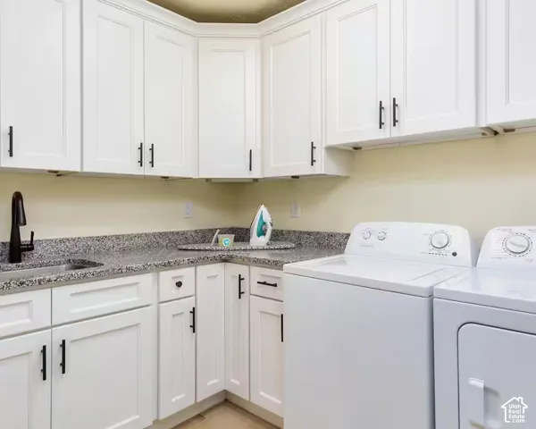 White shaker-style cabinetry with matte black hardware, granite-style countertops, and an undermount sink with a matte black faucet
