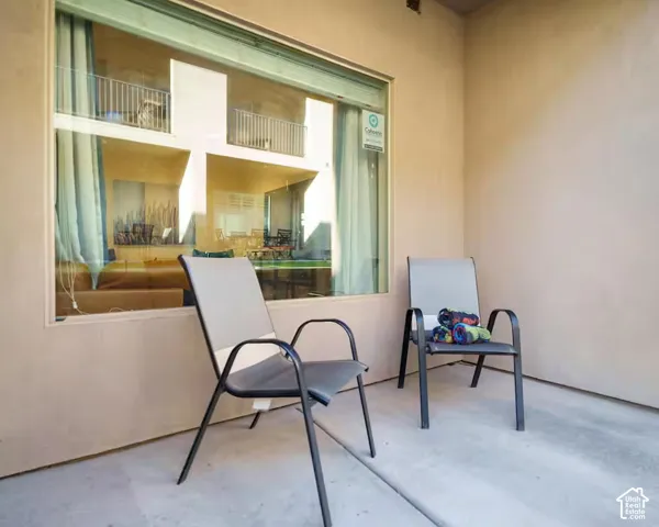 Concrete patio with stucco exterior walls and large window