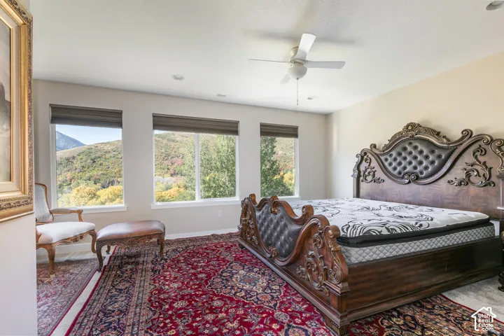 Triple window array, integrated ceiling fan, recessed lighting, neutral wall tones, and crown molding