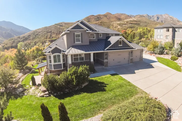 Multi-level residence featuring a three-car garage, stone and stucco exterior, bay window, and a concrete driveway