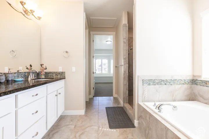 White vanity with a dark granite countertop and undermount sink