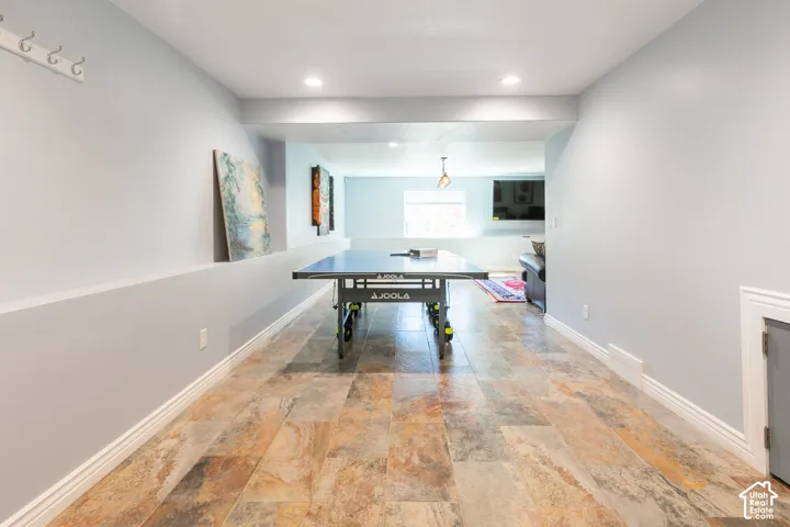 Spacious interior featuring multi-toned tile flooring, recessed lighting, and a neutral wall palette