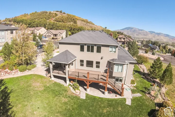 Two-story exterior with a covered deck, an open deck, and a lower-level patio
