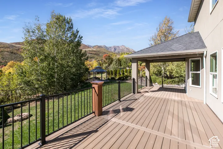 Expansive outdoor deck with composite decking, black metal railings, and a covered patio area