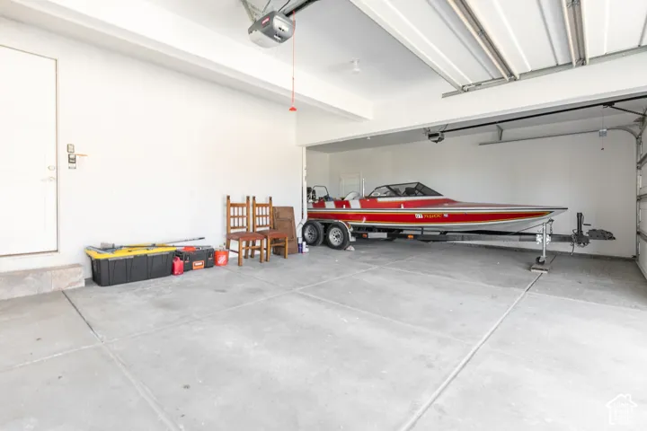 Attached two-car garage featuring a concrete floor and an automatic garage door opener