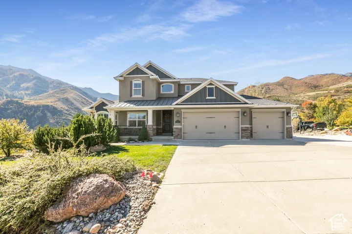 Stucco exterior with stone accents, covered front porch, and an attached three-car garage