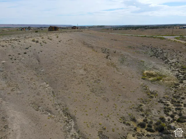 Expansive, undeveloped parcel featuring natural terrain and distant structures