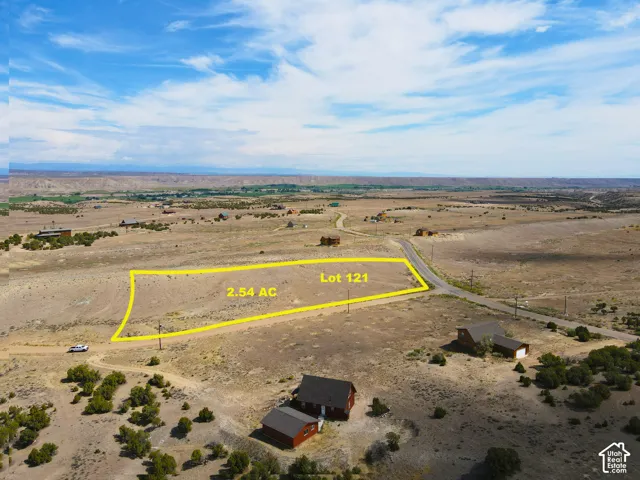 2.54 acre lot with direct road access, featuring a vast, open terrain with distant natural scenery