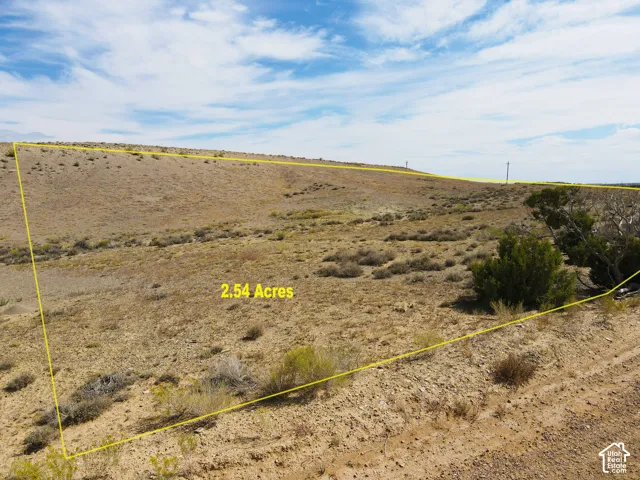 Expansive 2.54-acre parcel featuring varied terrain, natural desert vegetation, and overhead utility lines
