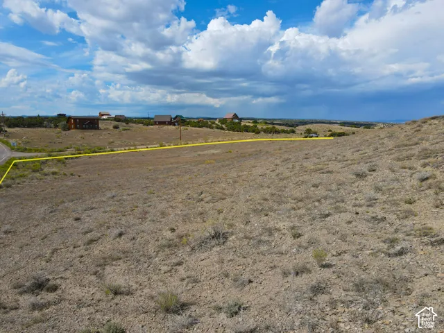Expansive undeveloped lot featuring a natural landscape and distant structures
