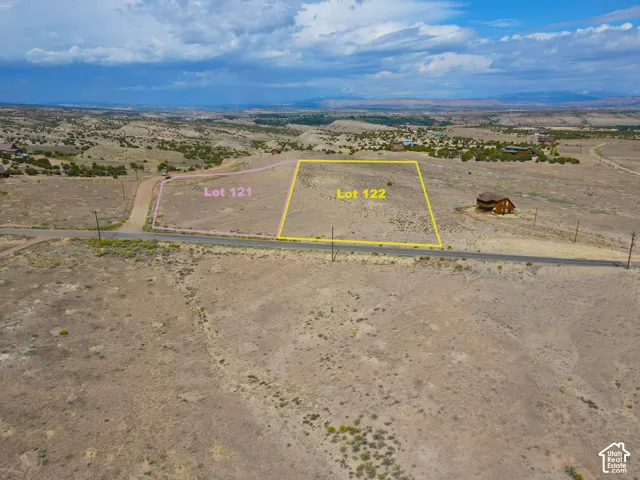 Expansive undeveloped land parcels, "Lot 121" and "Lot 122," featuring natural terrain and distant mountainous scenery