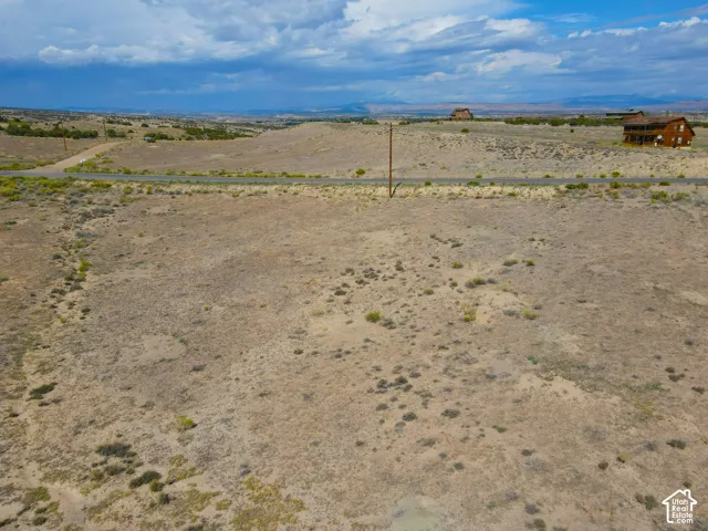 Expansive undeveloped land featuring natural terrain and distant structures