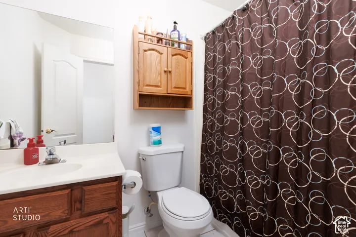Vanity with wood-finish cabinetry, integrated sink, and wall-mounted mirror