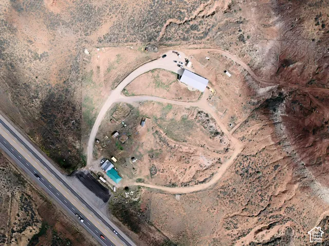 Expansive property with a large industrial-style building, multiple smaller structures, and a winding driveway