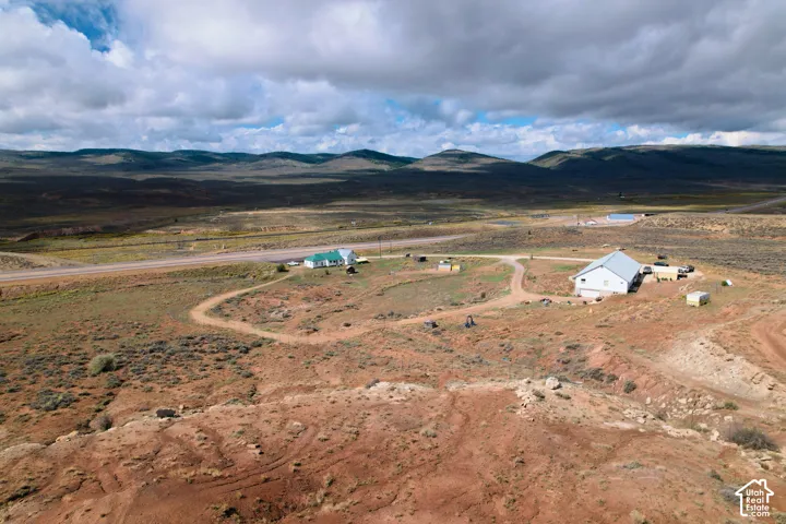 Expansive undeveloped land featuring a two-story structure and a single-story structure