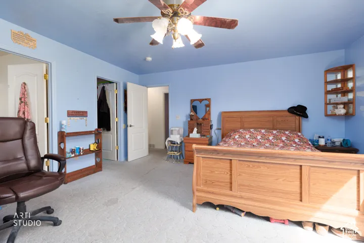 Carpeted flooring, ceiling fan with light fixture, and multiple doorways