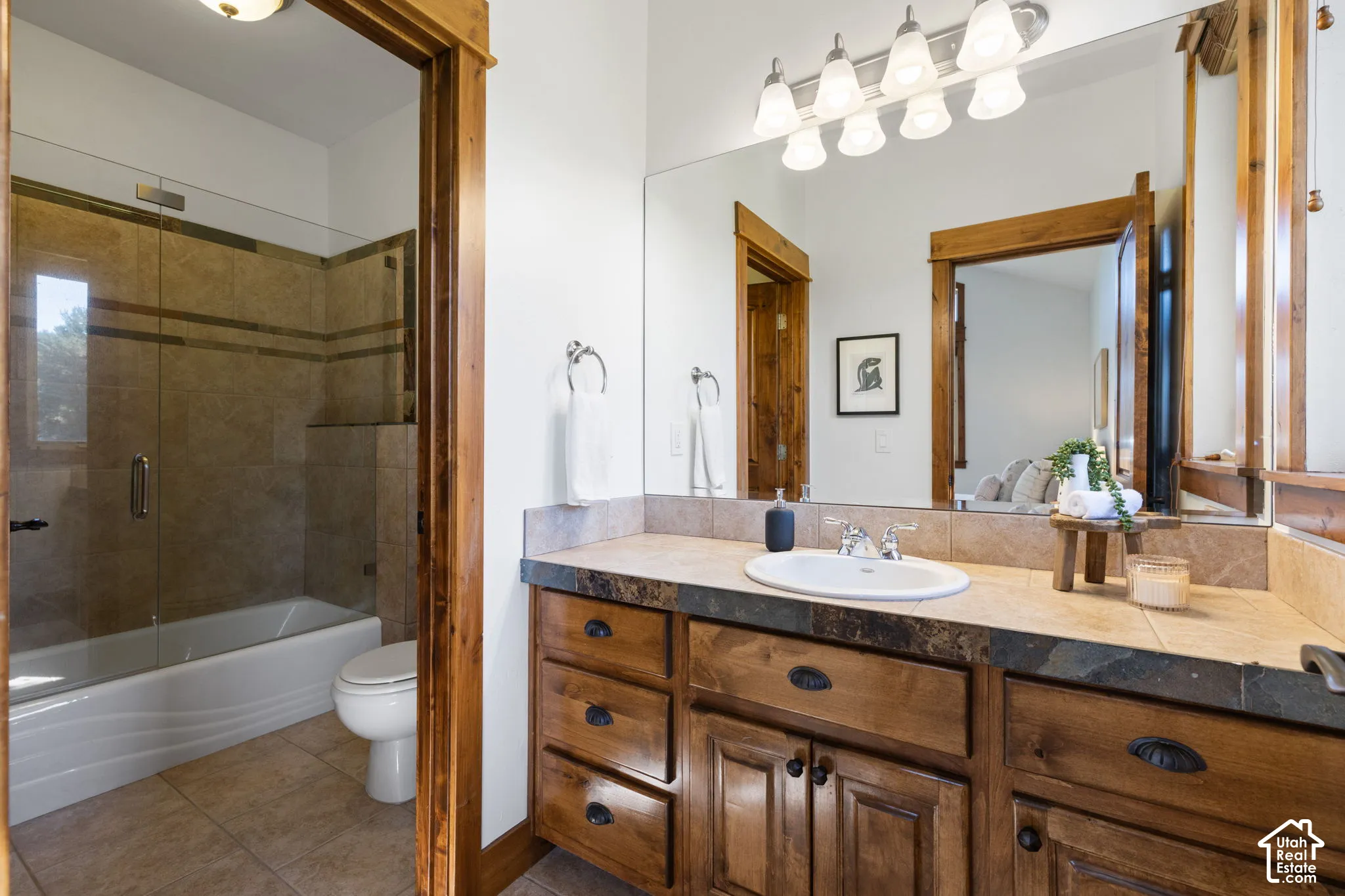 Custom wood-finish vanity with an integrated sink, tile countertop, and a full-width mirror