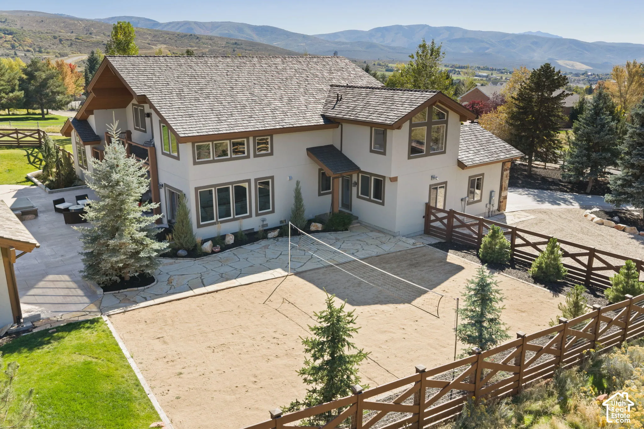 Exterior with a neutral stucco finish, multi-pane windows, and a shingle roof