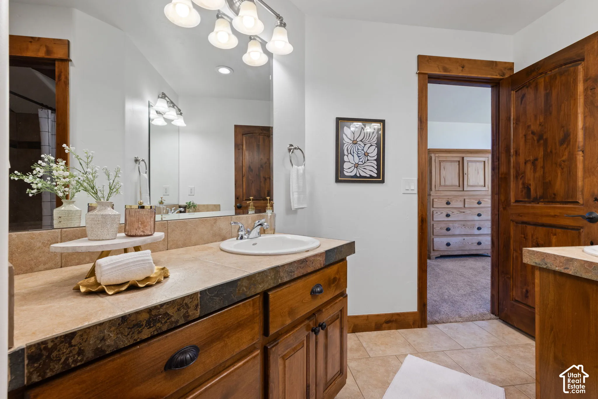 Dual vanity with undermount sinks, wood cabinetry, and a stone countertop