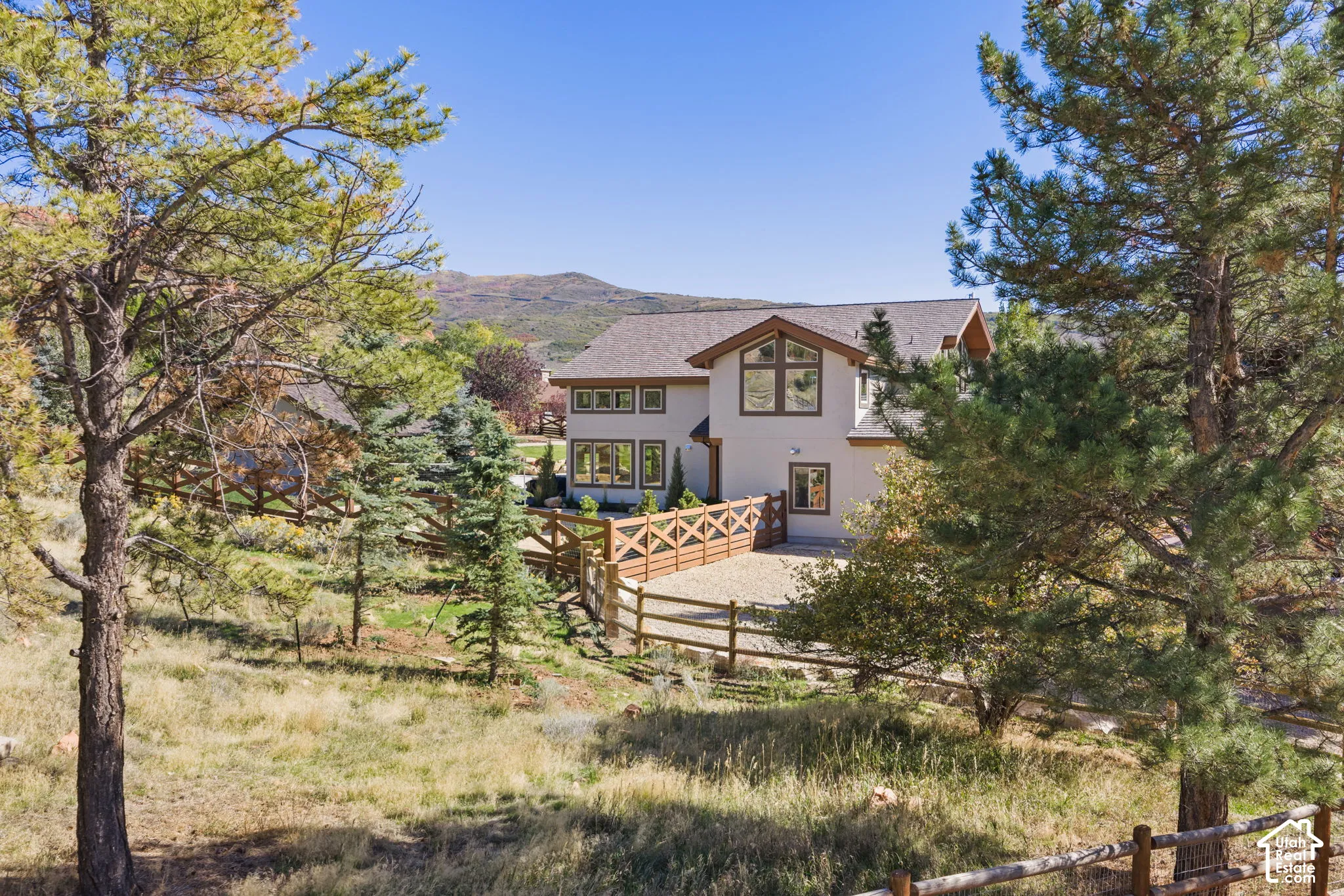 Two-story residence with a light-colored exterior and a brown roof