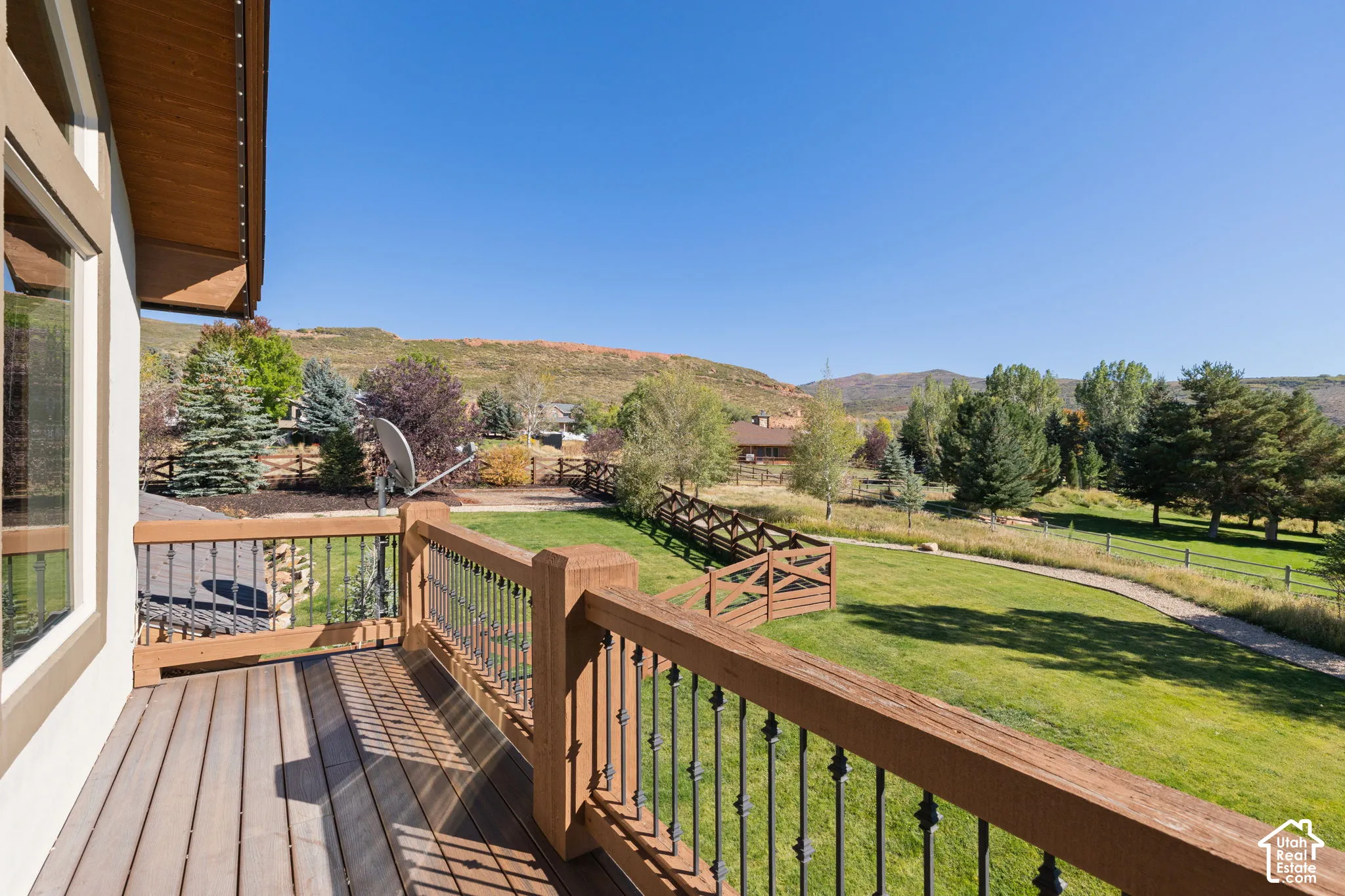 Expansive outdoor deck with wood-finish flooring and wrought iron railings