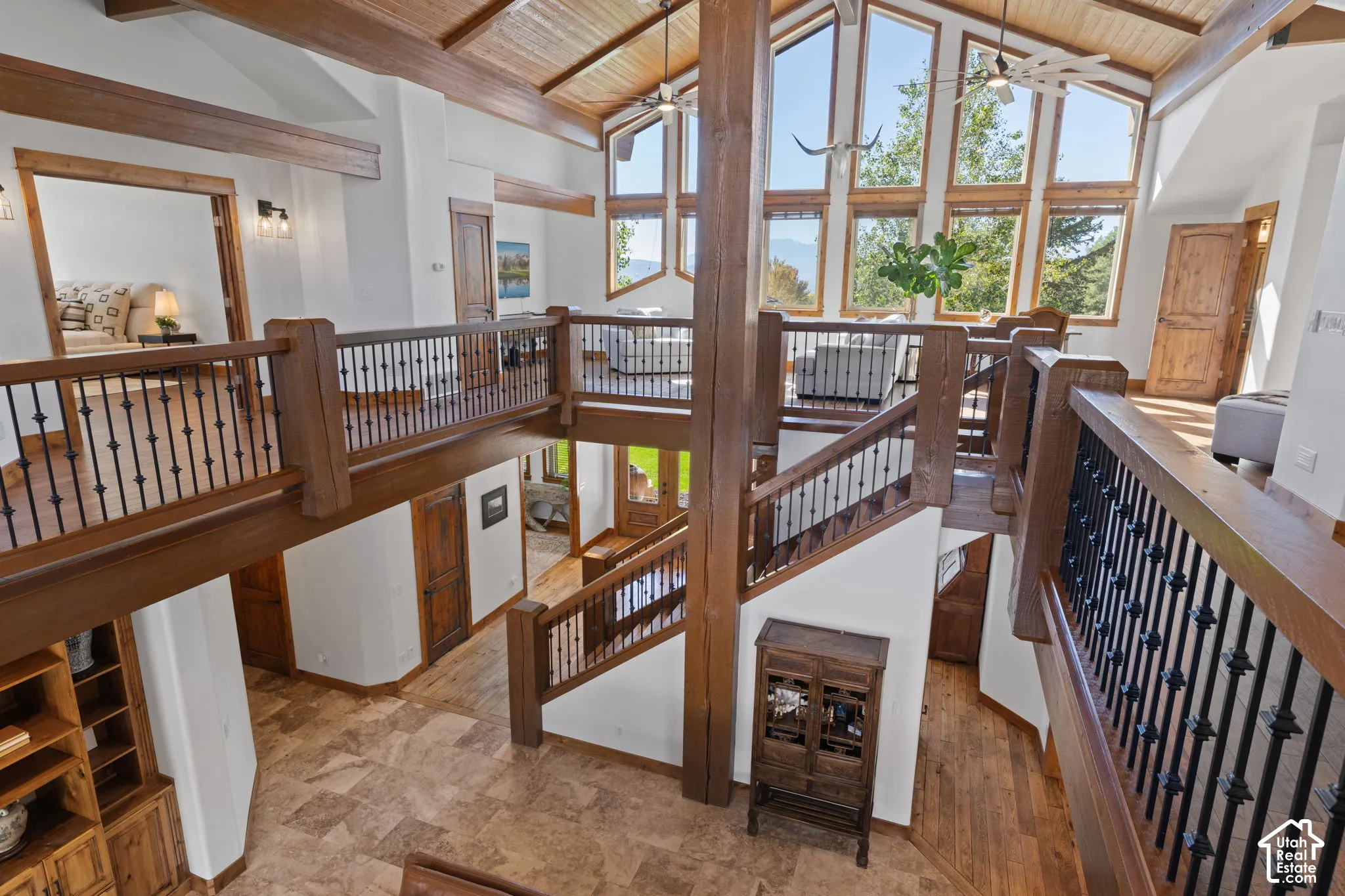 Vaulted wood-paneled ceiling with exposed beams, multi-level design, and an array of large windows