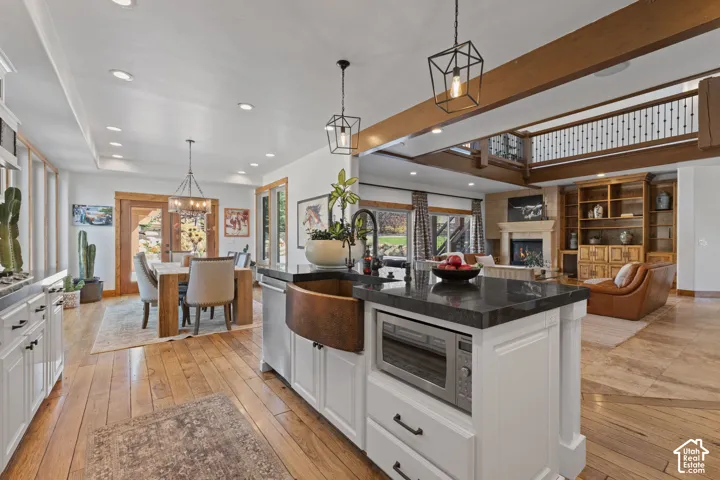 Central kitchen island with a copper farmhouse sink and stone countertop