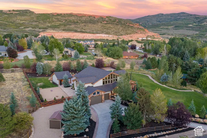 Architectural residence featuring a multi-car garage, extensive landscaping, and a separate outbuilding