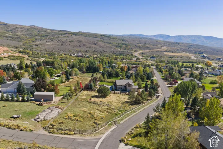 Expansive natural landscape with varied topography, residential properties, and a paved roadway system